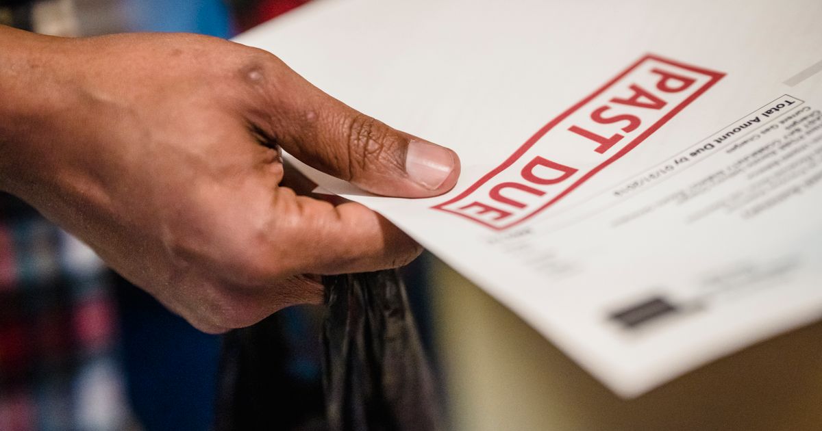 Hand holding a bill stamped past due