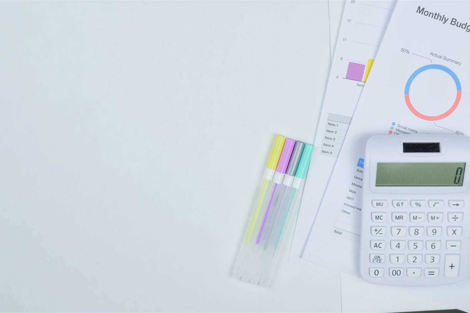 Photograph of a calculator and budget planning documents on an office desk
