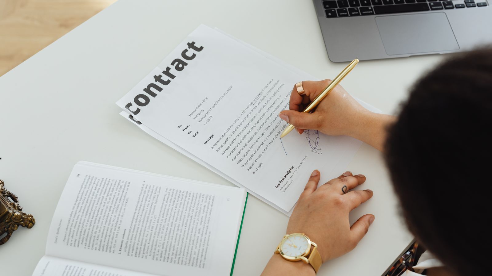Photograph of a hand signing a school fee policy document with a fountain pen