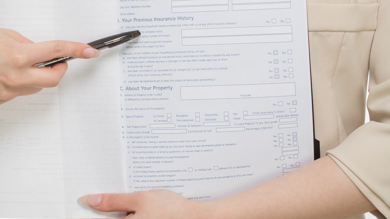 Photograph of an insurance adviser and a client reviewing and signing a policy document at a desk