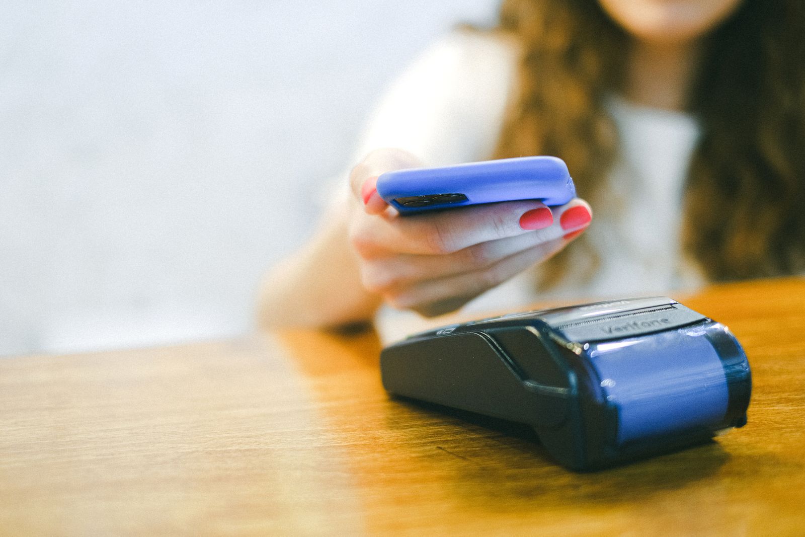 Photograph of a parent paying school fees with her smartphone