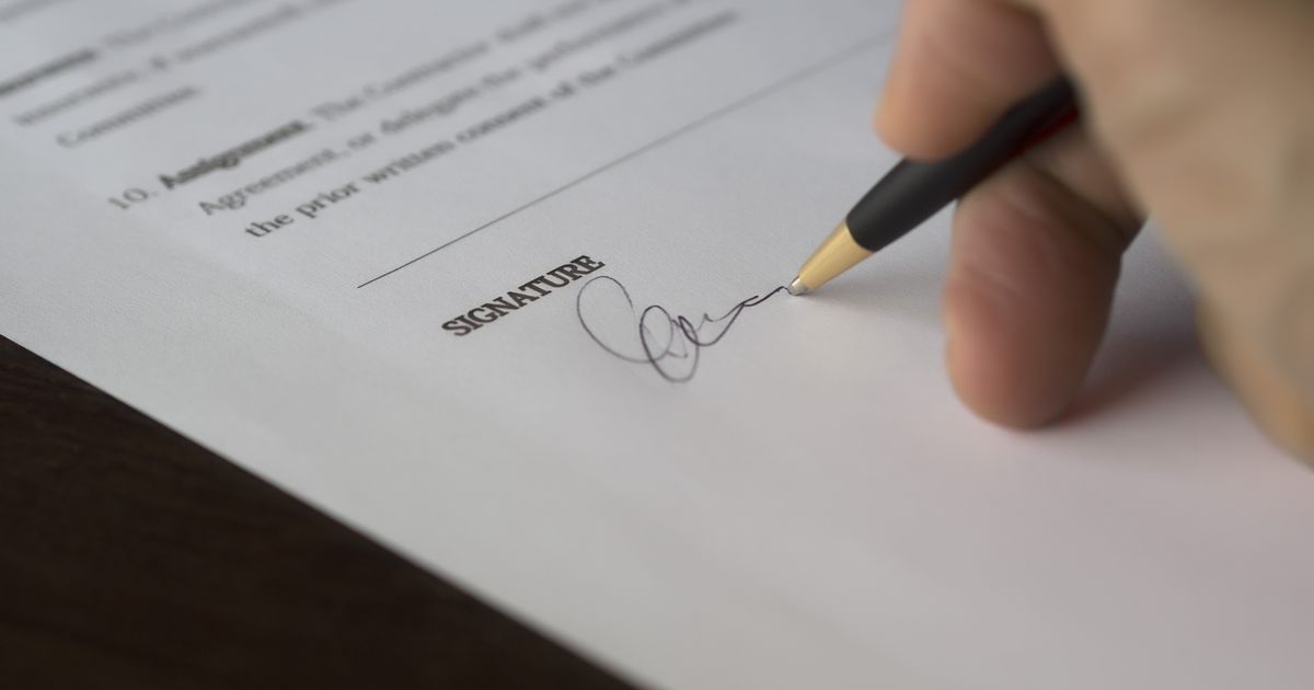Hand signing a school fee policy document